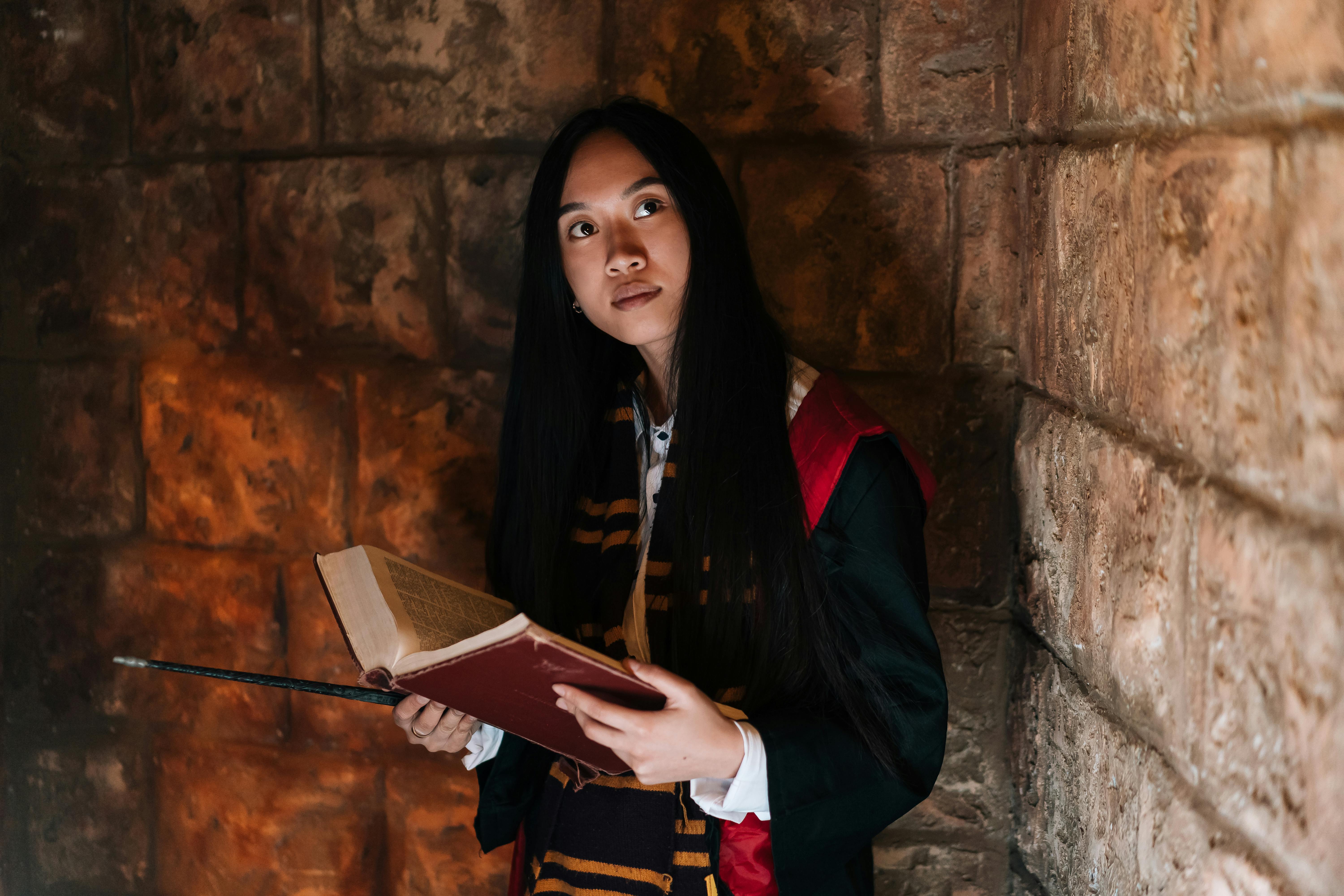 pexels-photo-8396700-8396700 A woman in a wizard costume holding a spellbook, evoking a magical atmosphere.